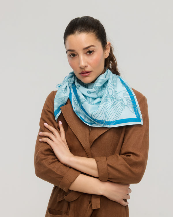 Carré foulard bleu en coton et soie porté autour du cou, Princesse & Dragon Montréal