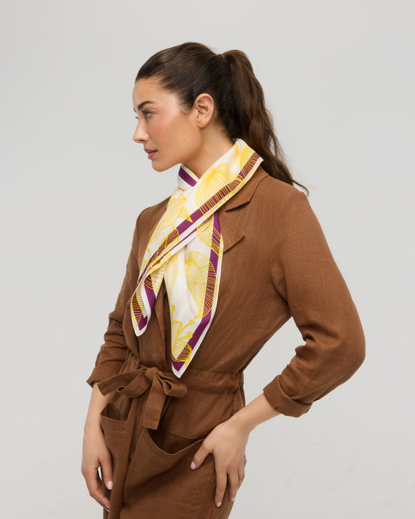 Carré foulard jaune et blanc en coton et soie porté autour du cou, Princesse & Dragon Montréal