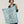 Foulard carré en soie et coton bleu ciel tenu déplié, montrant le motif floral dessiné au trait et la bordure bleu vif, Princesse & Dragon