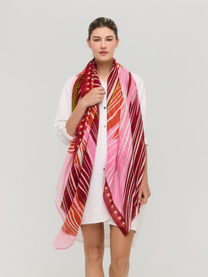 Foulard graphique en coton rouge, rose et orange porté autour du cou, collection printemps été Princesse & Dragon Montréal