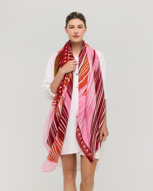 Foulard graphique en coton rouge, rose et orange porté autour du cou, collection printemps été Princesse & Dragon Montréal