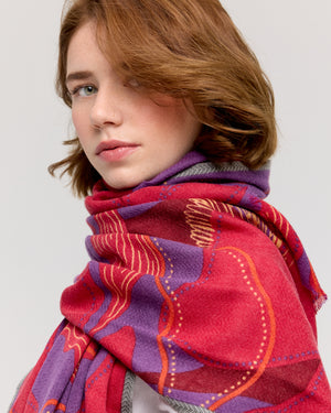 Foulard en laine mérinos avec motif floral, couleurs rouge, violet et bordeaux, bordure à chevrons et détails de pois sur les pétales, fabriqué à la main par Princesse & Dragon. Accessoire féminin et raffiné.