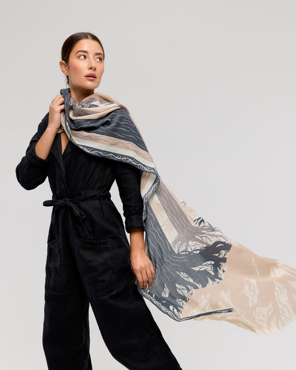 Foulard en laine mérinos doux et léger, dans des tons anthracite et beige avec motif inspiré des forêts québécoises. Fait à la main, idéal pour l’hiver et les soirées fraîches.