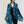 Foulard rectangulaire en fine laine mérinos bleu vif à motif végétal aux formes organiques noires et tiges rouges, bordure rayée rose et bords frangés, porté ouvert sur les épaules, Princesse & Dragon