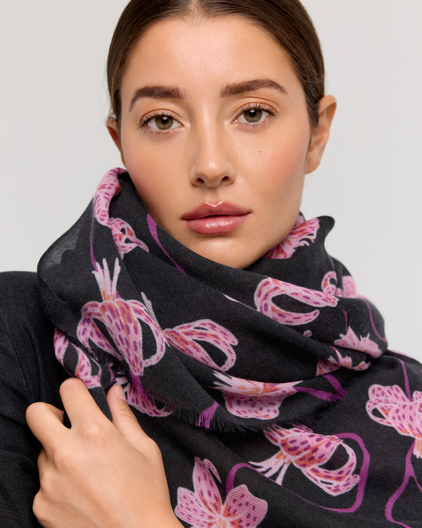 Foulard en laine mérinos avec motif floral, nuances de rose et violet sur fond noir, fabriqué à la main par Princesse & Dragon. Accessoire élégant pour rester au chaud