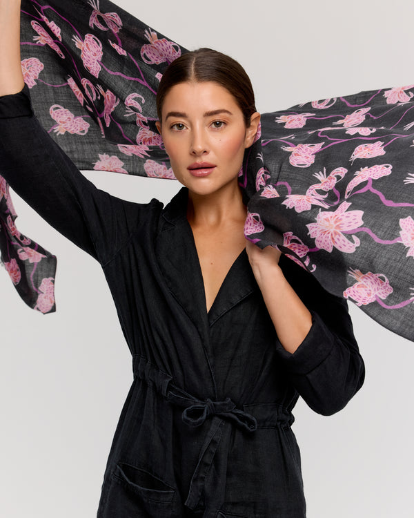 Merino scarf with a floral design in pink and purple on a black background, crafted by hand by Princesse & Dragon. Perfect for adding a chic touch while staying cozy