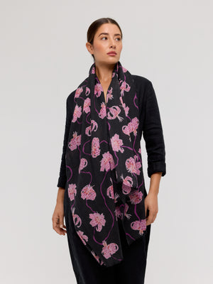 Merino wool scarf with floral pattern, shades of pink and purple on a black background, handmade by Princesse & Dragon. Elegant accessory to stay warm