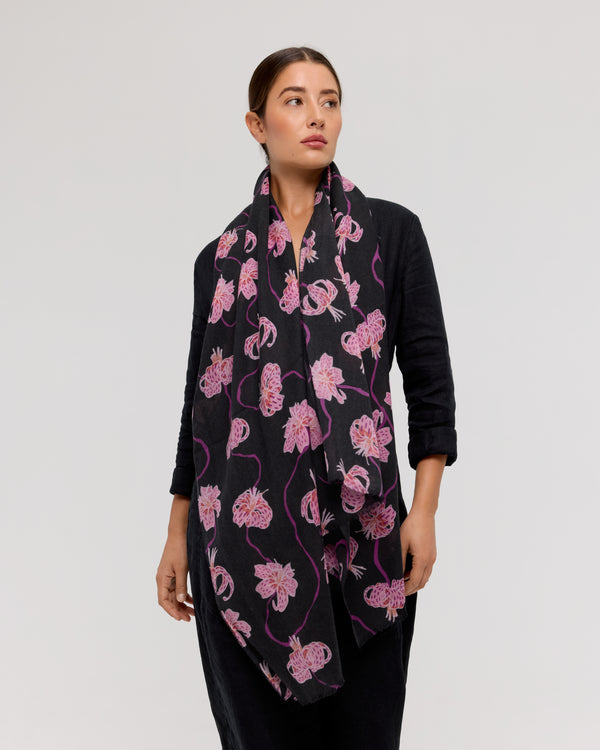 Merino wool scarf with floral pattern, shades of pink and purple on a black background, handmade by Princesse & Dragon. Elegant accessory to stay warm