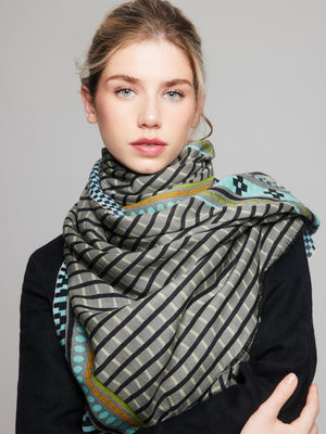 Soft and lightweight merino wool scarf with black, gray, and bright accents of sky blue, green, orange, and lime. Handcrafted, versatile for all-season wear.